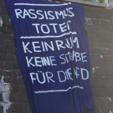 Banner "Rassismus tötet - keinen Raum, keine Straße für die AfD"